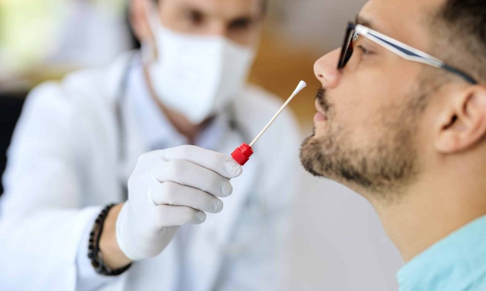 Close-up of young man getting PCR test at doctor's office during coronavirus epidemic.