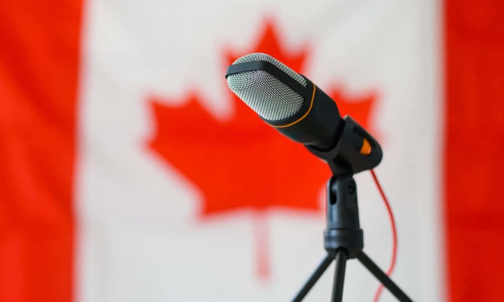 Microphone in front of the Canadian flag. Close up.
