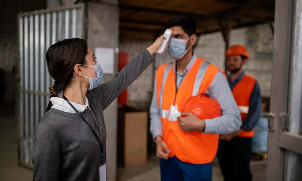 woman-taking-temperature-colleague